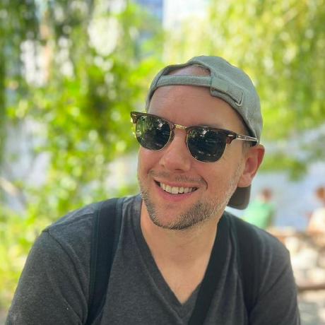 The creator behind Shady Cow Games, wearing sunglasses and a cap, smiling outdoors